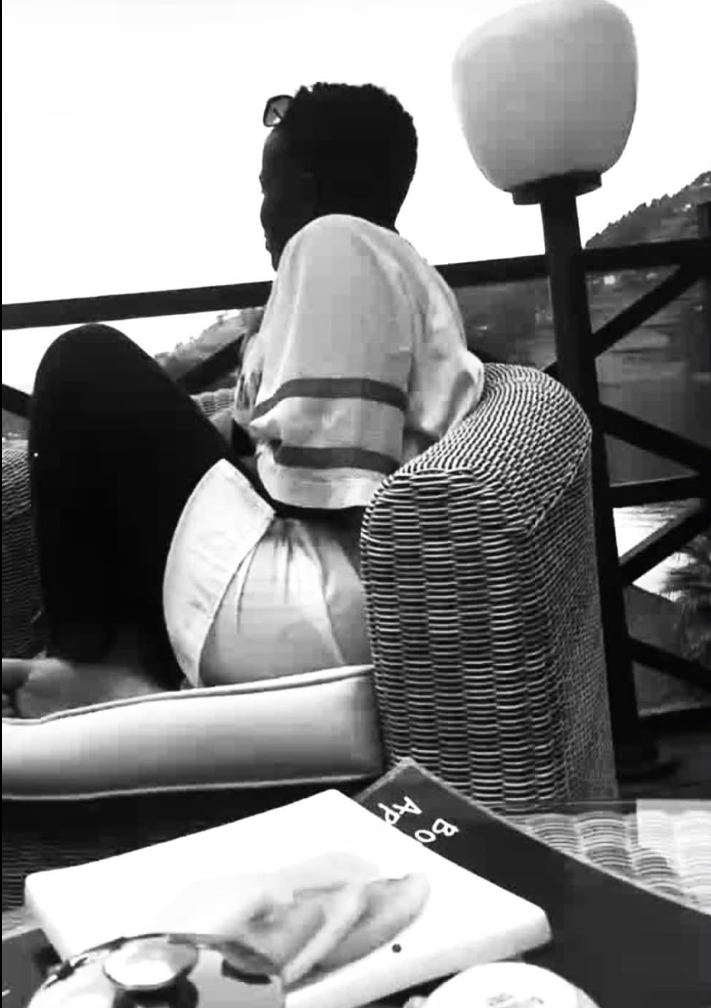 A woman sitting on a balcony overlooking the lake